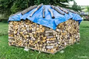 Blaue Holzabdeckplane mit Holzblöcken als Befestigung